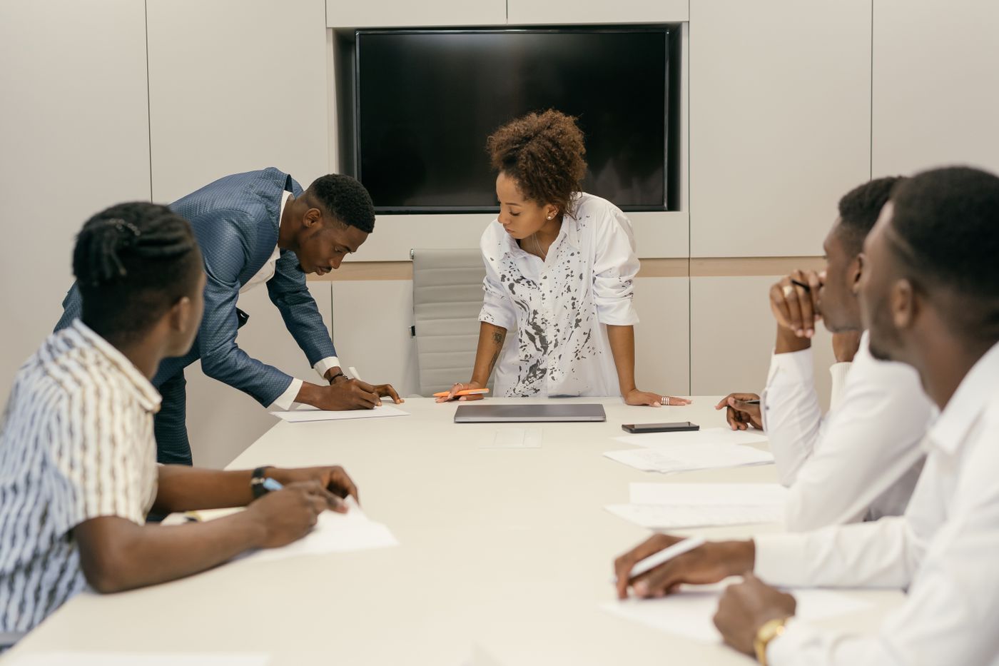 Black business team reviewing documents around a conference table