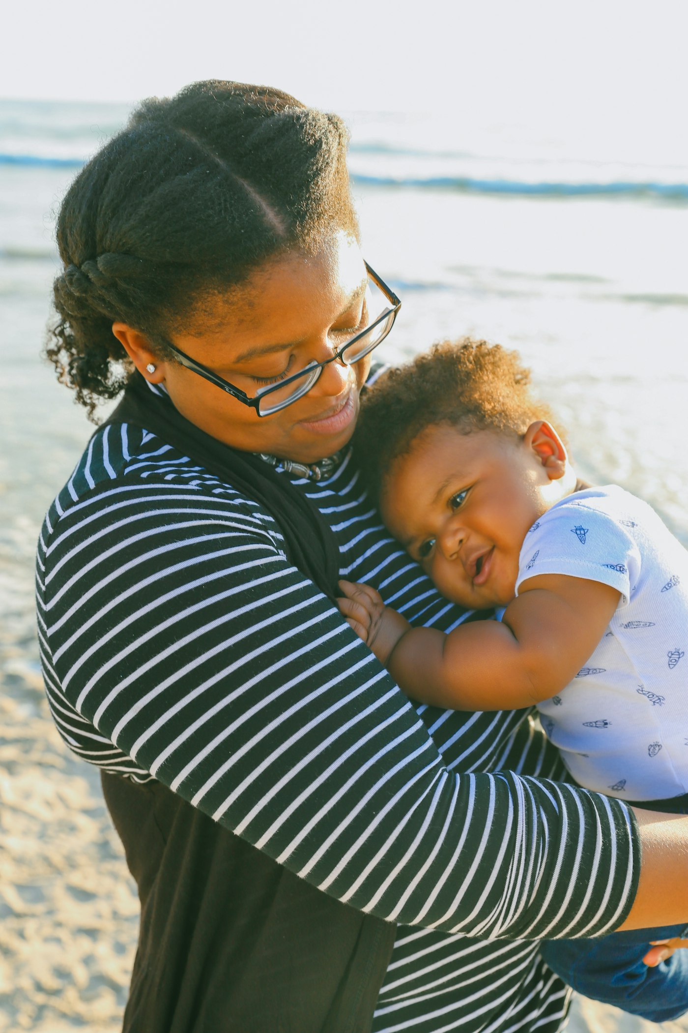 Black mother holding her baby while caring for family health needs