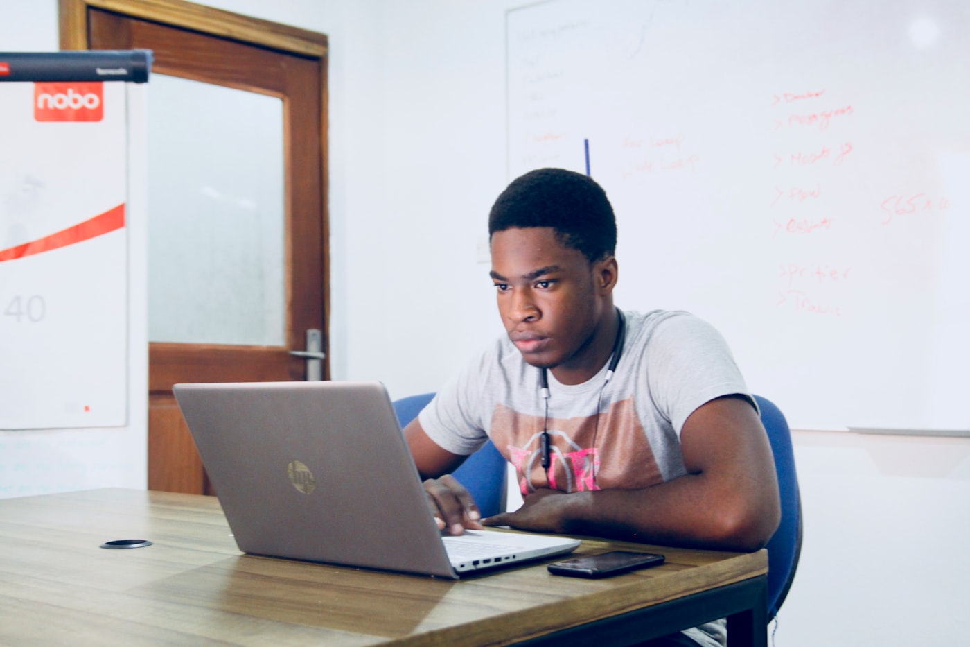 Black student working on a laptop in a study room